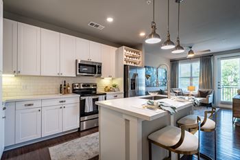 A modern kitchen with white cabinets and a large island.